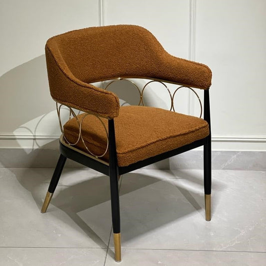 Rust bouclé lounge chair with golden ring back design