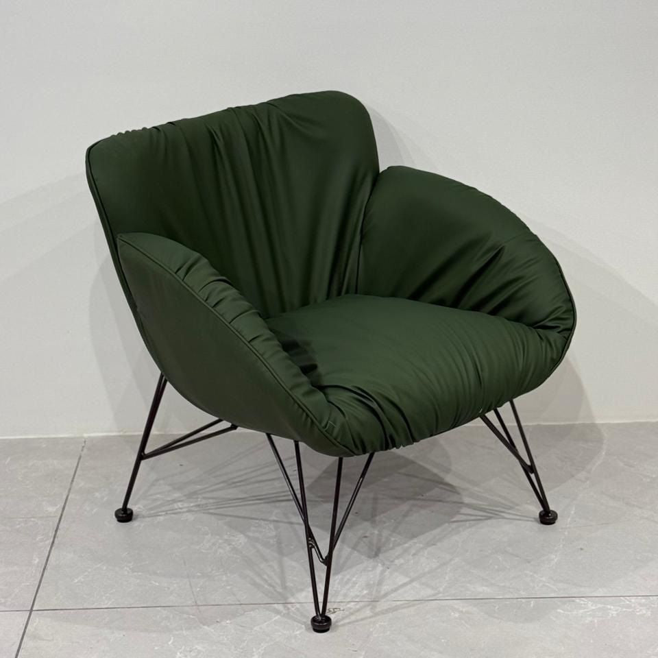 Green leisure chair with black metal legs on a light gray floor.