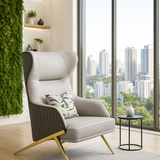 Grey wingback lounge chair with gold legs and quilted sides in a luxury setting.