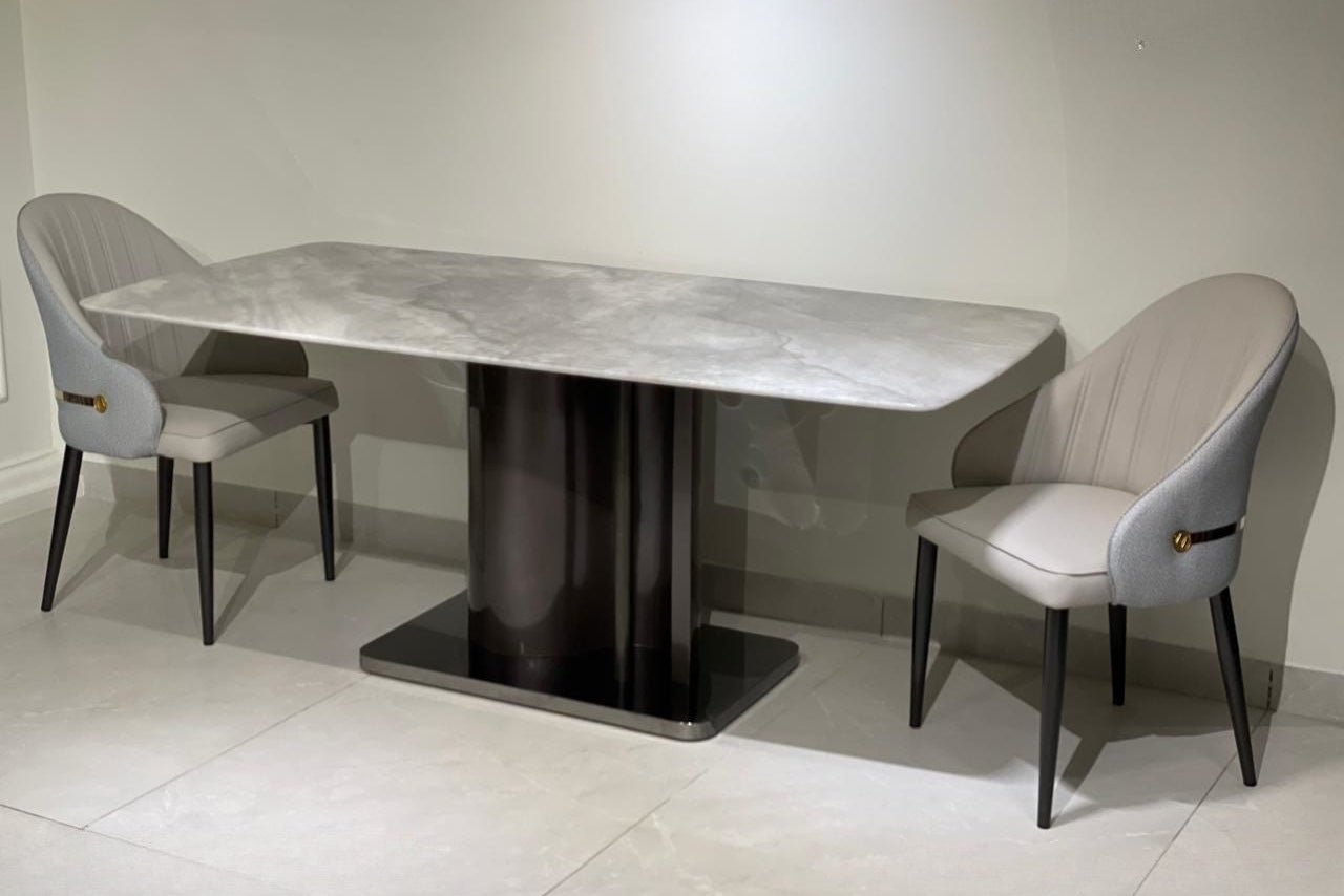 Dining table with marble-like surface and modern chairs in a minimalistic setting