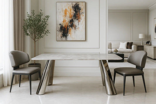 Luxury marble coffee table with angled metallic base and grey chairs in a refined modern living room.