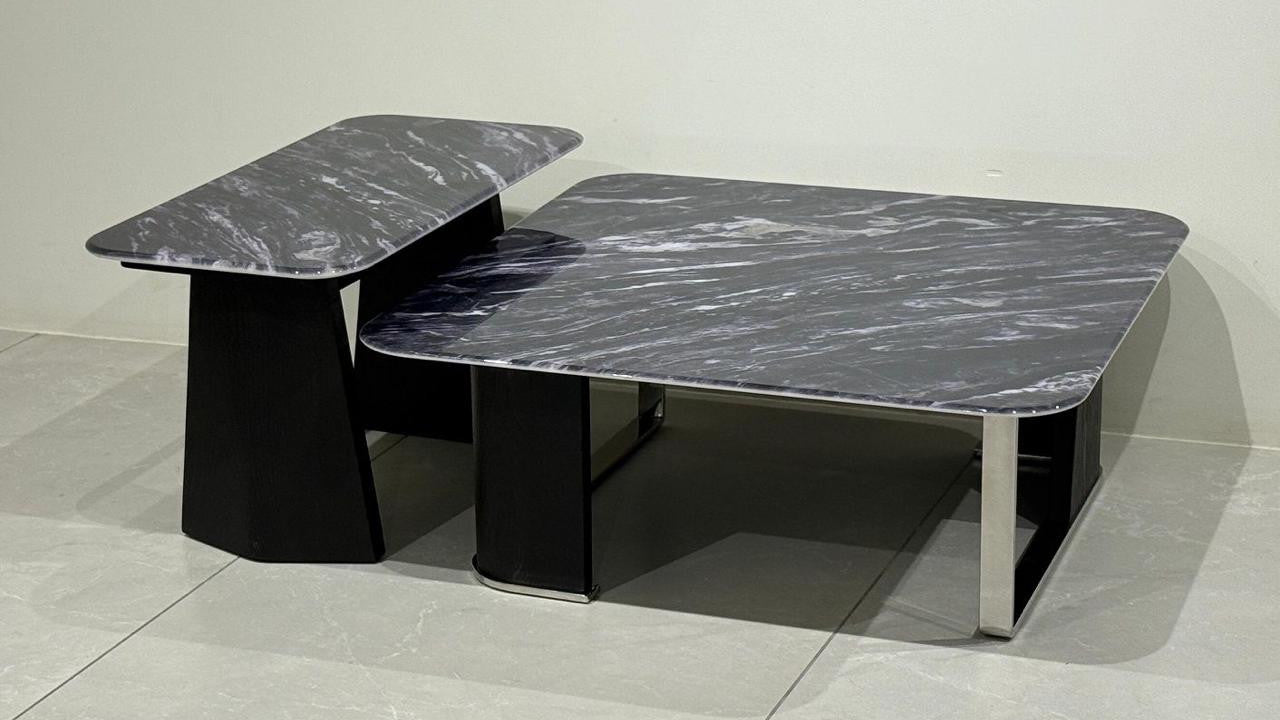 Two-piece marble center table set on a tiled floor with a neutral background