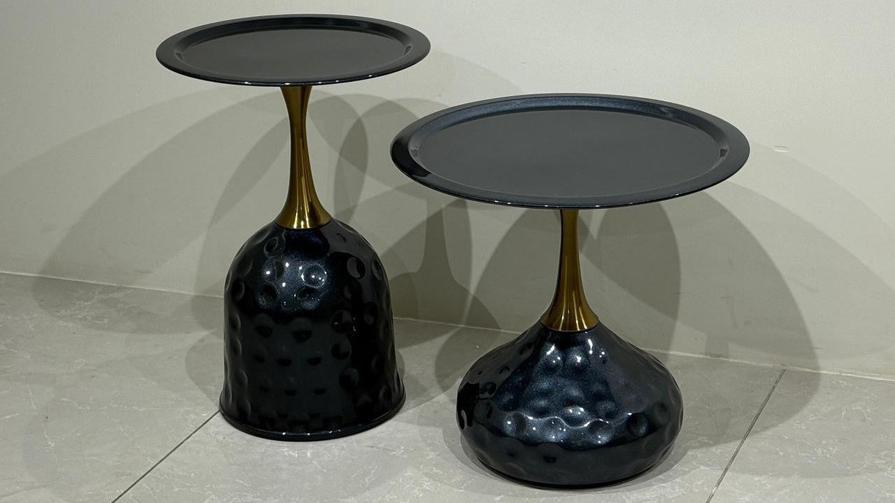 Two black center tables on a tiled floor with a neutral background