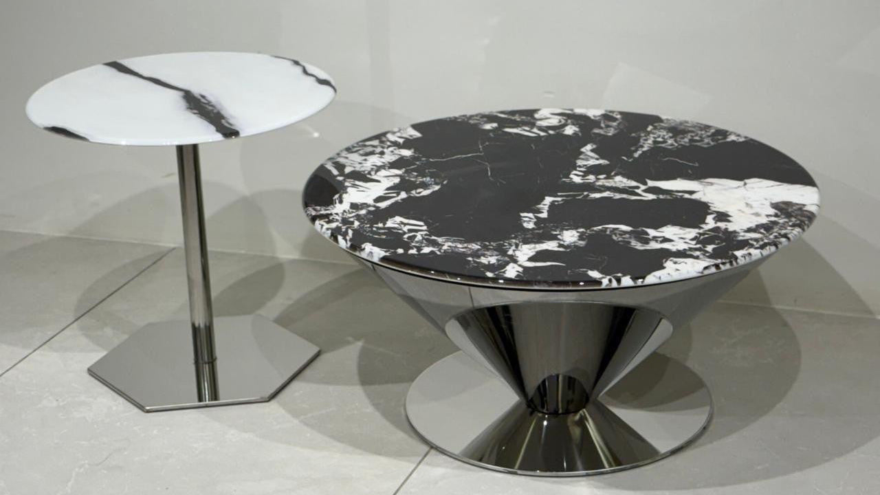 Round marble table with a smaller matching side table on a light gray floor.