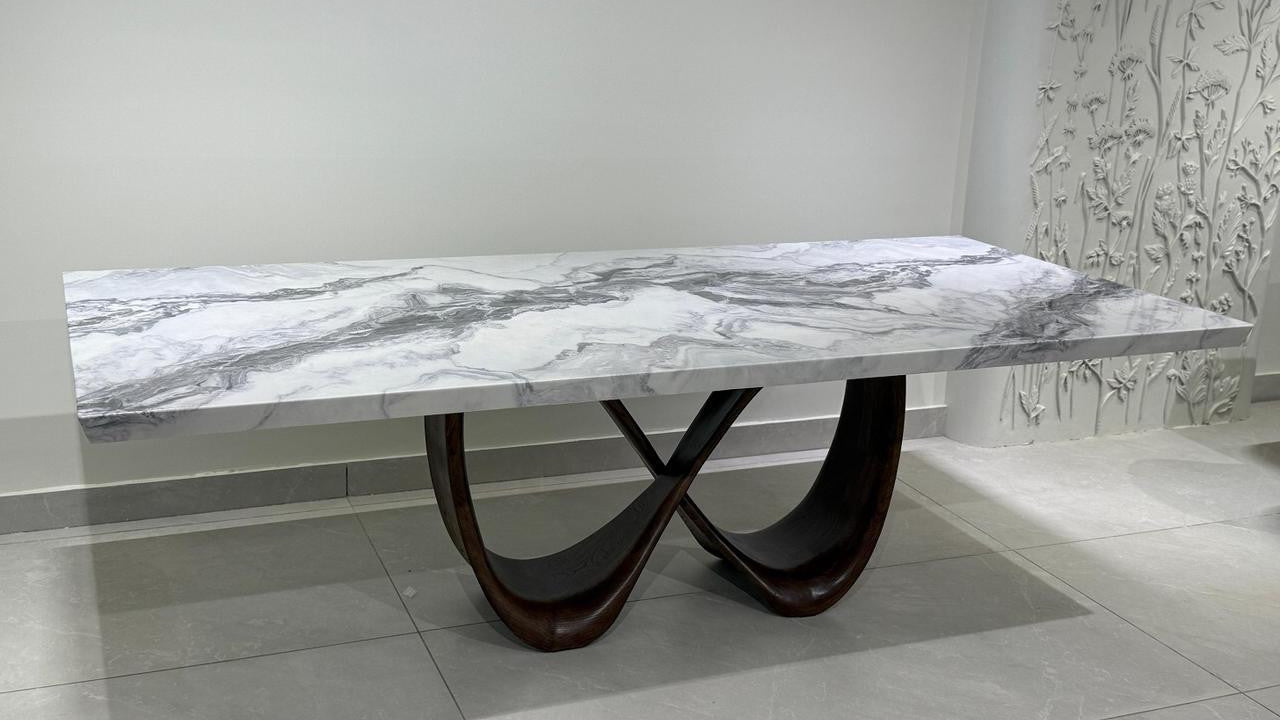Dining table with marble-like top and dark wood base in a room setting