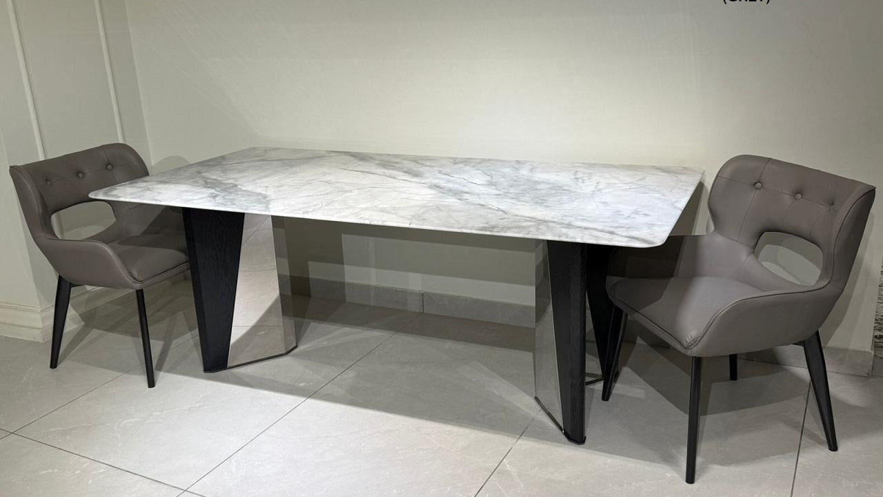 Dining table with marble-like surface and two chairs in a room.