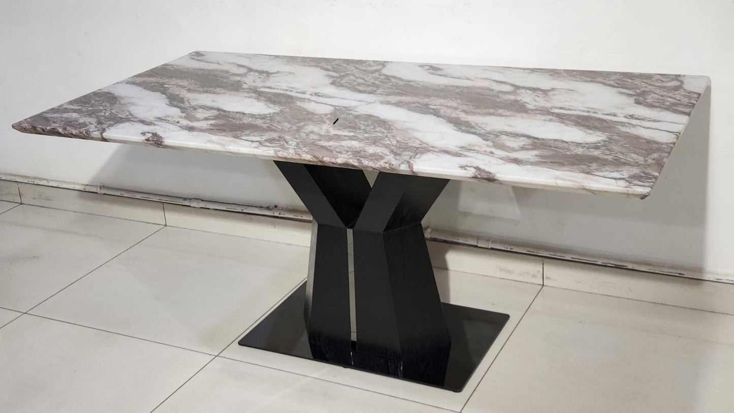 Dining table with marble top and black base on a tiled floor.