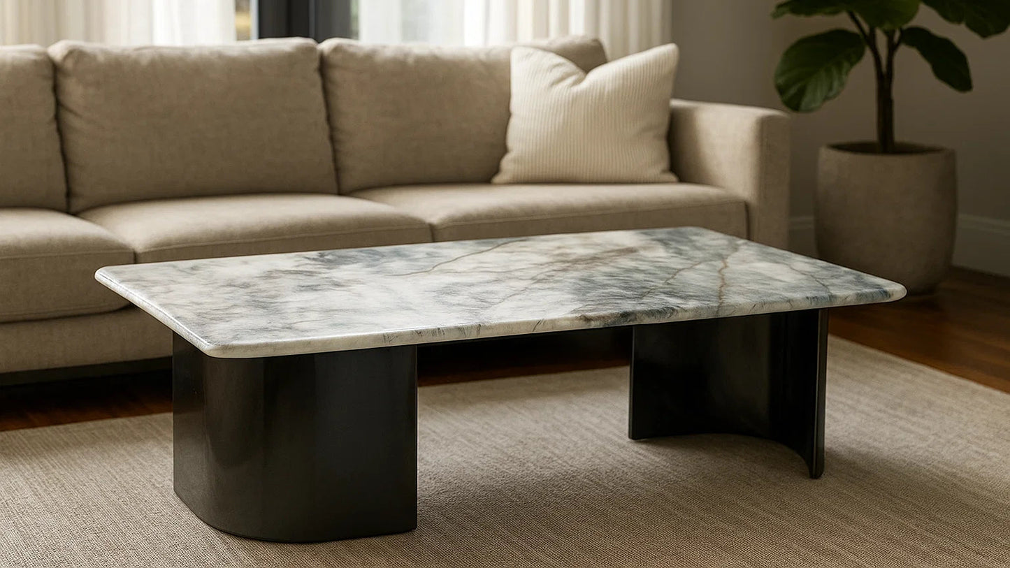 Marble coffee table in a living room setting with a beige sofa and plant.
