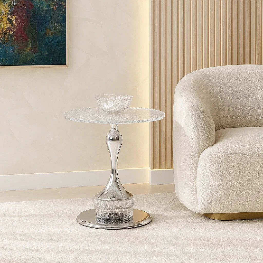 Modern side table with marble top and chrome base in a living room setting.